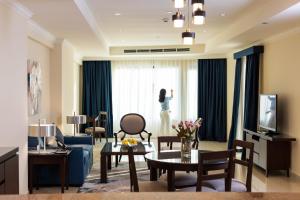 a woman standing in a living room looking out the window at Sedra Arjaan by Rotana in Doha