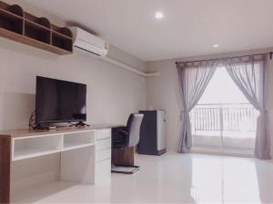 a living room with a tv and a large window at PJ PLACE in Ban Bang Samak