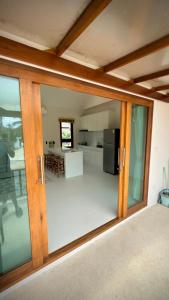 a room with glass doors and a kitchen at Canal Villa in Chaloklum