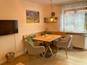 a dining room with a wooden table and chairs at Ferienwohnung Bergleuchten in Obermaiselstein