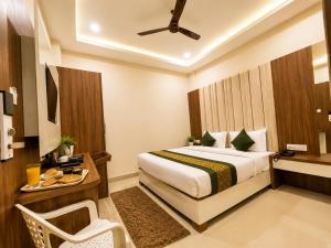 a bedroom with a bed and a table and a chair at HOTEL NEAR KASHI VISHWANATH VARANASI SHREE R-KRISHNA - wifi - Lift - FAMILY HOTEL in Varanasi