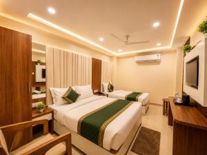 a hotel room with two beds and a television at HOTEL NEAR KASHI VISHWANATH VARANASI SHREE R-KRISHNA - wifi - Lift - FAMILY HOTEL in Varanasi
