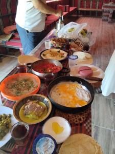 a table topped with lots of different types of food at Mujib Castle Gate Camp in Dhībān
