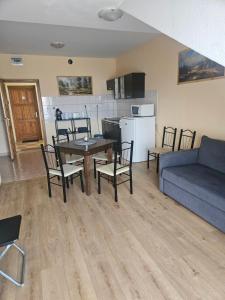 a living room with a table and chairs and a couch at Cserke-Thermál Apartman in Cserkeszőlő