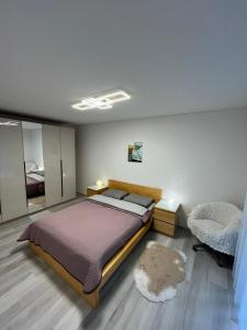 a bedroom with a large bed and a chair at Cozy apartment in Zurich
