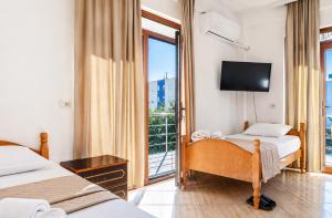 a hotel room with two beds and a television at Bar Hotel Tirana in Kukës +19 photos