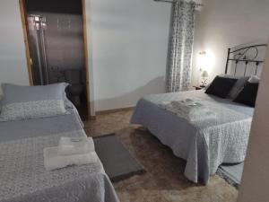 a bedroom with two beds and a table with towels at Alojamiento Acuario in Espiel