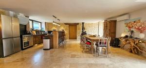 a kitchen with a table and a dining room at PETIT PARADIS 24 in Groléjac
