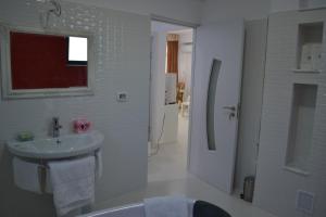 a white bathroom with a sink and a shower at City Park Residence in Constanţa +46 photos