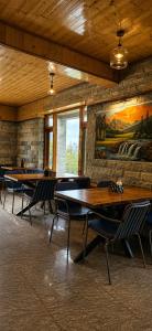 a room with tables and chairs and a painting on the wall at Foresta Living Kasol in Kasol