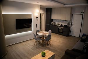 a kitchen and a living room with a table and chairs at Kalma Apartment Xanthi Center in Xanthi