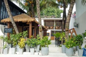 a resort with palm trees and a building with plants at Ithaa Inn Kamadhoo in Baa Atoll