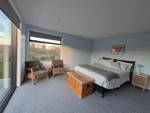 a bedroom with a bed and a table and a chair at Unit at Curio in Curio Bay