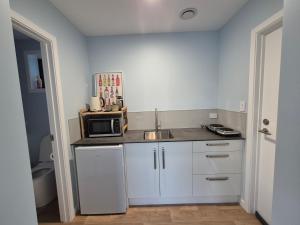 a small kitchen with a sink and a microwave at Unit at Curio in Curio Bay