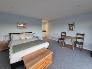 a bedroom with a bed and a table and chairs at Unit at Curio in Curio Bay