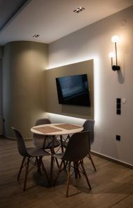 a table and chairs in a room with a tv at Kalma Apartment Xanthi Center in Xanthi