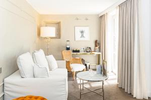 a living room with a white couch and a table at Mas des Herbes Blanches Hôtel & Spa – Relais & Châteaux in Joucas