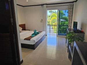 a bedroom with a bed and a sliding glass door at Cha-Tinnie Hotel in Phra Ae beach