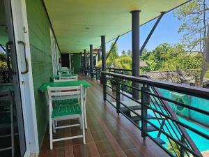 a row of tables and chairs on a balcony at Cha-Tinnie Hotel in Phra Ae beach