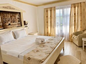 a large bed in a room with a large window at Vidra Dacica in Vidra