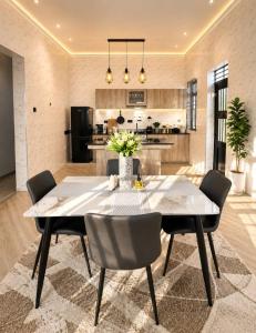 a dining room with a table and chairs and a kitchen at The Serenity Hideaway in Arusha