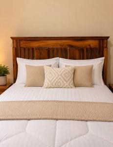a large bed with white sheets and pillows at The Serenity Hideaway in Arusha +10 photos
