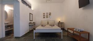 a bedroom with a white bed and two tables at Margaritari Sifnos in Platis Gialos