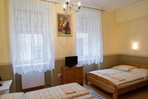 a bedroom with two twin beds and a window at Taverna panzió in Sopron