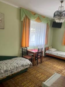 a bedroom with a bed and a table and chairs at Coffee Hostel in Lviv