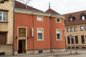 ein orangefarbenes Gebäude an der Ecke einer Straße in der Unterkunft Taverna panzió in Sopron