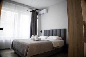 a bedroom with a bed with two stuffed animals on it at Kalma Apartment Xanthi Center in Xanthi