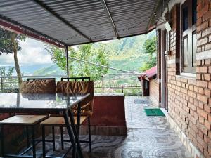 a patio with a table and chairs on a balcony at Penance Homestay in Khokna +117 photos