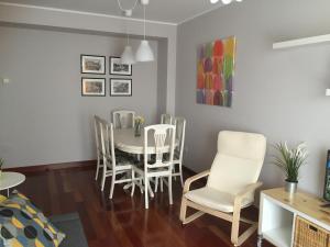 Apartamento Playa Poniente في خيخون: غرفة طعام مع طاولة وكراسي