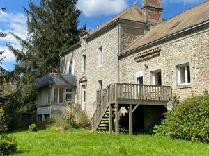 an old brick house with a wooden porch and a deck at Le Manoir de Gourvinec in Saint-Nolff