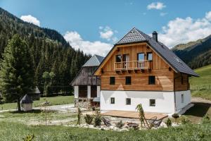 a large wooden house with a balcony in a field at Das Detox Almhaus in Pusterwald