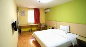 a bedroom with a white bed and green walls at 7 Days Inn Baoding Railway Station in Baoding +260 photos