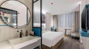 a bathroom with a bed and a sink and a mirror at 7 Days Inn Baoding Railway Station in Baoding