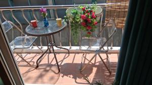 a table and two chairs on a balcony with flowers at Daol in Seoul