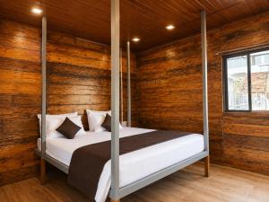 a bedroom with wooden walls and a bed with four posts at Royal Shouryas Resort in Kolhapur
