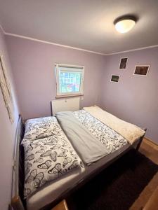 a small bedroom with a bed and a window at Chatka Bartka in Komarówka