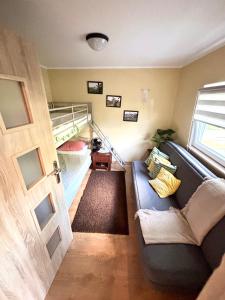 a living room with a couch and a bunk bed at Chatka Bartka in Komarówka +14 photos
