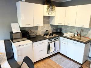 a kitchen with white cabinets and a stove top oven at Chatka Bartka in Komarówka