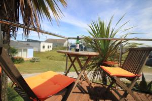 a table and two chairs with a bottle of wine at Wee Cott in Hayle