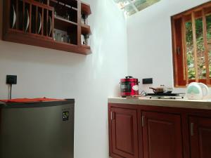 a kitchen with a refrigerator and a counter top at Mukalawatta Villa in Matara