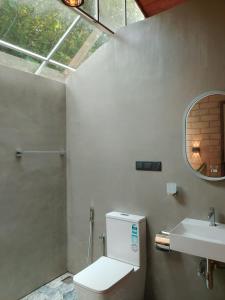 a bathroom with a toilet and a sink and a mirror at Mukalawatta Villa in Matara