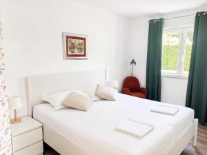 a white bed in a room with a window at Villa Rubea in Cavtat
