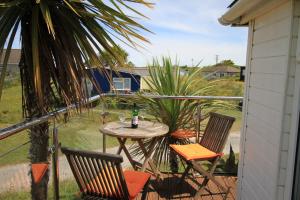 a patio with a table and chairs on a balcony at Wee Cott in Hayle +9 photos