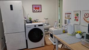 a kitchen with a washing machine and a table at Daol in Seoul
