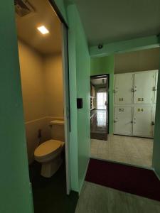 a bathroom with a toilet and green walls at DK1Hostel in Chaweng