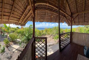 a view from the porch of a house with a view of the ocean at Kampa Lodge in Tano +7 photos
